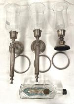 Two silvered metal candle wall lights with waisted glass shade; a similar table lamp; a vintage ship