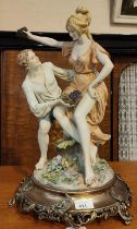 A Capodimonte style group of a boy and a girl with grapes, signed "Bennechiro", bronzed metal base,