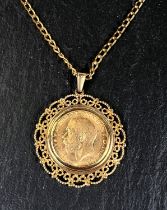 A George V sovereign in filigree pendant mount, on flattened curb chain, gross 18gm