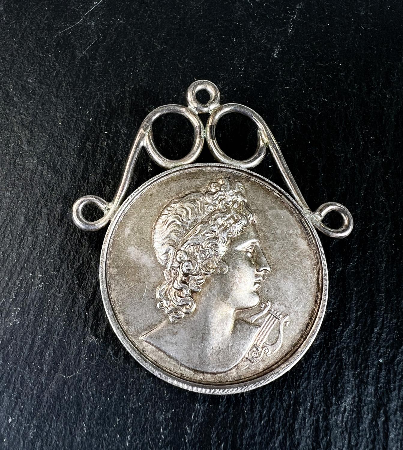 A hallmarked silver musical medal, Apollo and his lyre to the front and inscription Bute Cumbrae and