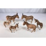 Two adult Beswick Donkeys and 2 Beswick Donkey foals; a bisque Beswick Donkey and another