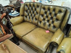 A green leather effect Chesterfield style reclining armchair with deep button back with studded