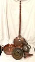 A copper warming pan and a copper pan with side handles and other copper ornaments