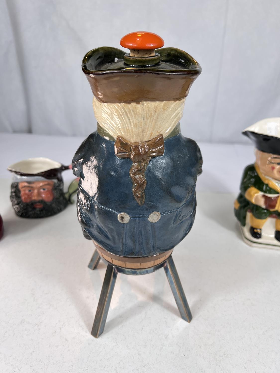 A novelty Doulton stoneware decanter in the form of a man sitting astride a barrel, tap under and - Bild 3 aus 4