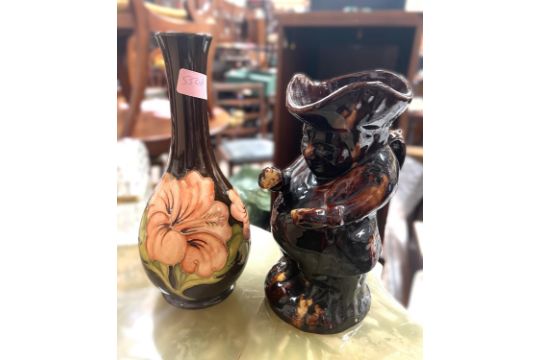 A Moorcroft hibiscus vase with brown glaze and a treacle glazed Toby jug.