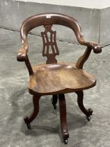 A Victorian mahogany desk armchair on quadripartite swivel support.