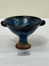 A Chinese stem bowl in a mottled blue high fired glaze. 5½" diam over handles.