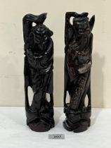 A pair of Chinese carved hardwood and white metal inlaid figures of immortals. 11" high.