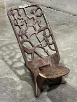 An African hardwood palaver or birthing chair, the pierced back carved with figures, crocodile and