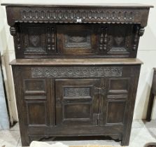 A Charles II joined oak press cupboard, with lozenge carved and fielded panels, the upper part