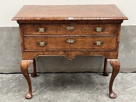 A George II walnut side table, the moulded top crossbanded and line inlaid, over two long line