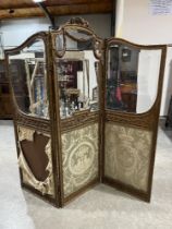 A late 19th Century French rococo revival three fold giltwood screen with bevelled glazed and silk