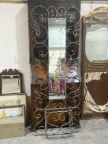 A wrought iron wall mounted hallstand with integral mirror plate. 73" high.