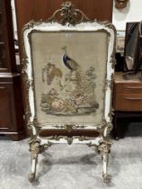 A Victorian parcel gilt gesso firescreen, the woolwork banner worked with a peafowl on a pedestal.