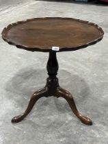 A 19th century mahogany snap-top table with piecrest edge on carved baluster column and tripod