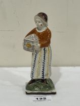 An early 19th Century Staffordshire pearlware figure of a young lady with caged bird. 5¾" high