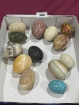 Twelve hardstone eggs with a papier-mache example.