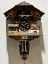 A German cuckoo clock, the two train movement with figure and water wheel automata. 10" wide