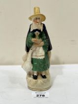 An early 19th Century Staffordshire figure group of Welsh woman with goose. 7¼" high.