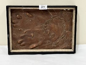 A framed plaster relief of chained hands. 12" wide.