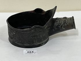 A Chinese bronzed handled bowl with relief decoration. 8" long.