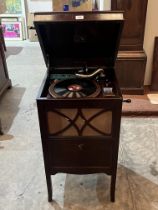 A 1920s mahogany HMV gramophone with a quantity of records and needles.