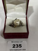 An 18ct Southsea pearl and diamond ring of modernist openwork design. The pearl 12mm diam approx