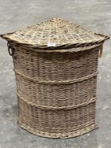 A wicker corner laundry basket.