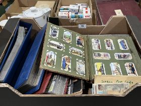 A box of cigarette cards in albums and sleeves.