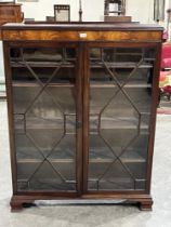 A mahogany bookcase enclosed by a pair of astragal glazed doors, on bracket feet. 40" wide