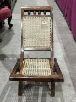 A rosewood folding chair with caned back and seat.