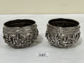 A pair of Indian silver bowls, decorated in high relief with continuous figure scenes or figures