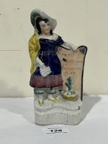 A 19th Century Staffordshire figure of a woman standing beside a gravestone with inscription 'To the