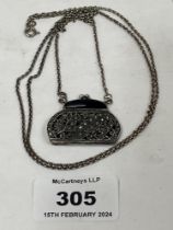 An early 20th Century silver filigree pendant in the form of an evening bag set with cut steels on