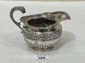 A 19th Century silver helmet form milk jug, the gadrooned body with a border of scrolled foliage and