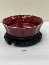 A Chinese sang-de-boeuf bowl on wood stand. 7½" diam. Base cracked.