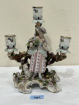 A 19th Century German porcelain figural three light candelabrum. 9¾" high. Damage, repairs.