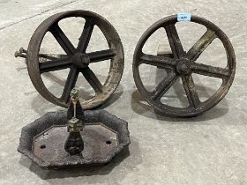 Two cast iron wheels and axles with a cast iron boot scraper.