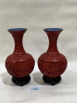 A pair of Oriental carved cinnabar baluster vases. 8" high.