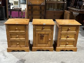 A pair of pine bedside chests and a pine bedside cabinet.