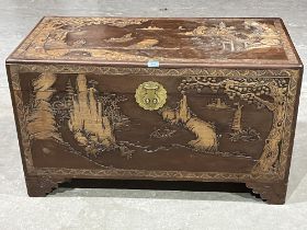 An early 20th Century Oriental camphorwood blanket chest carved in bas-relief with landscapes.