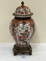 A Japanese Imari inverted baluster vase and domed cover with gilt metal mount to neck, stand and