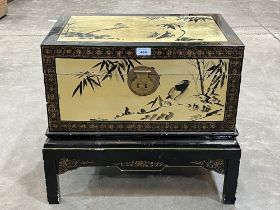 A Chinese black lacquer chest with gilt decoration of birds and prunus. 23" wide.