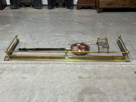 A brass extending fender, a copper warming pan, trivet and a poker.