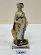 An early 19th Century Staffordshire pearlware figure of a lady. 7" high.