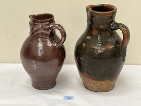 An 18th Century salt glazed jug, 11½ high (cracked) and an antique green glazed earthenware pitcher,