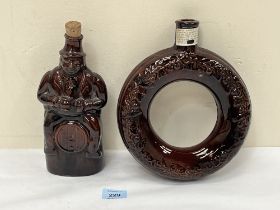 A 19th Century treacle glazed figural whisky flask, 9¼" high, and a 19th Century treacle glazed