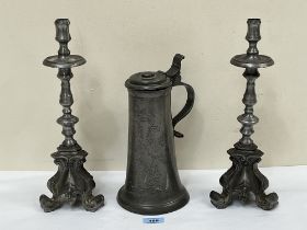 A pair of pewter gothic style candlesticks, 15" high and a 19th Century German pewter flagon.