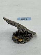 A loaded silver figure of an owl in flight, with glass eyes. 3" wide.