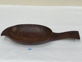 An ethnic carved treen paddle form bowl, 26½" long.